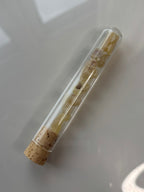 Packshot, Weihrauch auf glänzendem Hintergrund in Glasröhrchen mit Korkverschluss