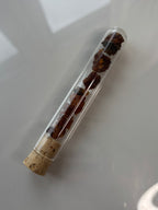 Packshot, Myrrhe auf glänzendem Hintergrund in Glasröhrchen mit Korkverschluss