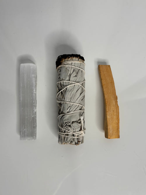 Palo Santo holz, Salbei und selenit Kristall auf weißem glänzenden hintergund, salbei ist etwas schwarz an der spitze
